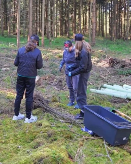 Teilnehmerinnen des Girls’ Day bereiten junge Eichen für die Pflanzung im Wald vor.
